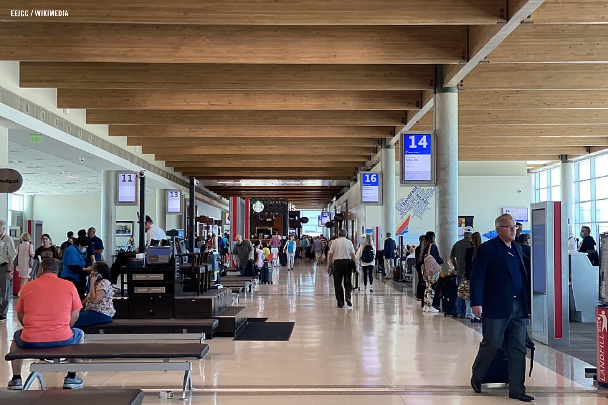 Travelers walking through an airport terminal concourse